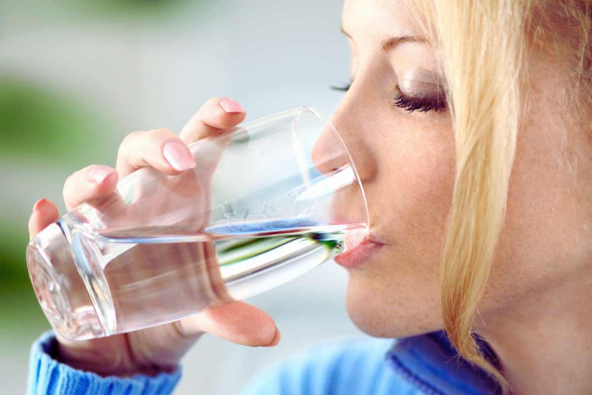 Donna che beve un bicchiere d'acqua