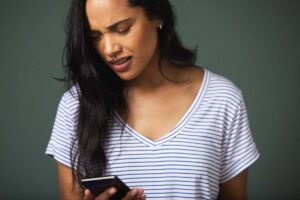 Ragazza che guarda lo smartphone preoccupata