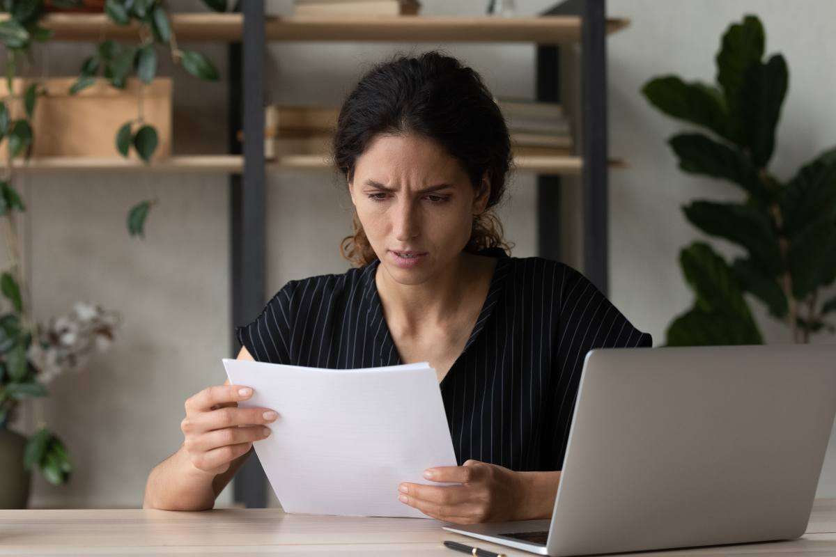 Donna che legge un foglio preoccupata