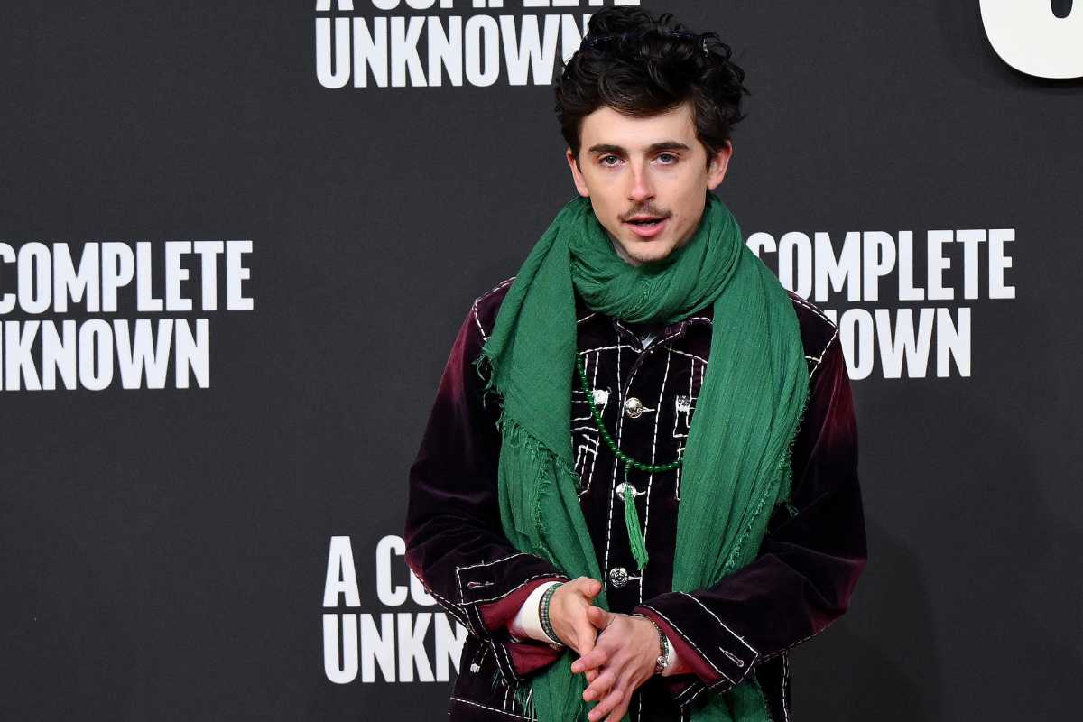 Timothée Chalamet con sullo sfondo il cartello pubblicitario del film A Complete Unknown