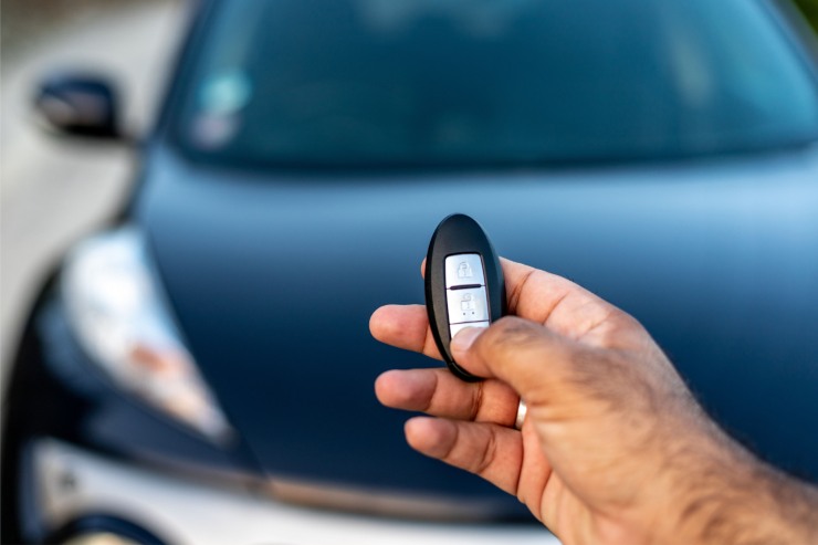 Uomo che chiude l'auto con la chiave a distanza