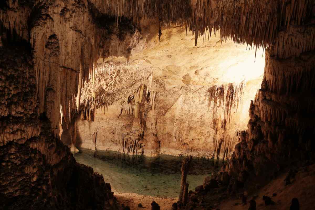 Interno di una grotta illuminato con un lago