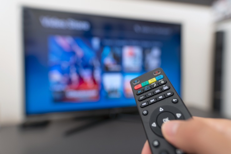 Persona che accende tv con servizio in abbonamento