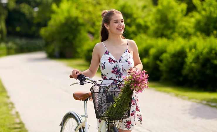 Donna che trascina a mano una bicicletta