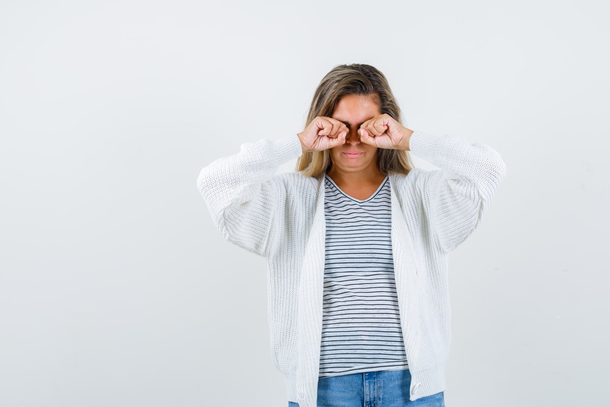 Donna che si strofina gli occhi con le mani 